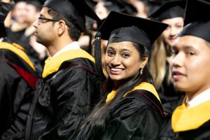Graduate student smiles during Fall Graduate Commencement ceremony