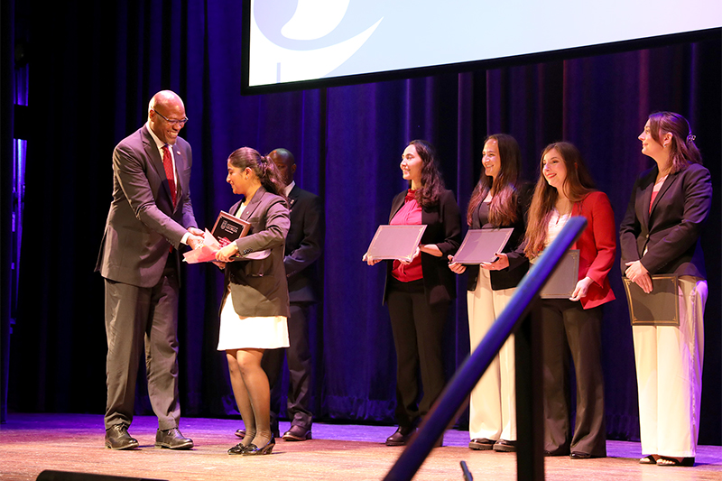 photo of Anshul, 2025 UGA 3MT Grand Prize Winner, accepting her award from Dean Ron Walcott