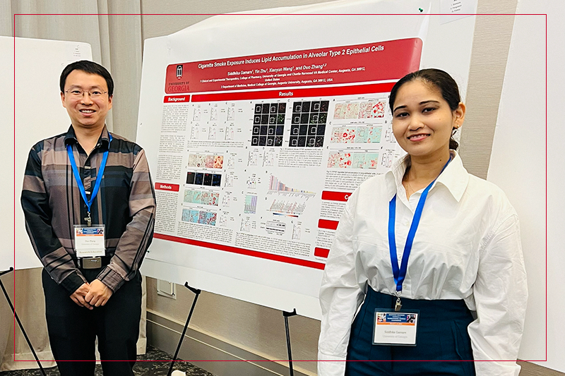 Dr. Duo Zhang and Siddhika Gamare presenting a research poster at a conference.