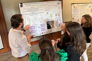 Taylor Martin discussing a poster with colleagues